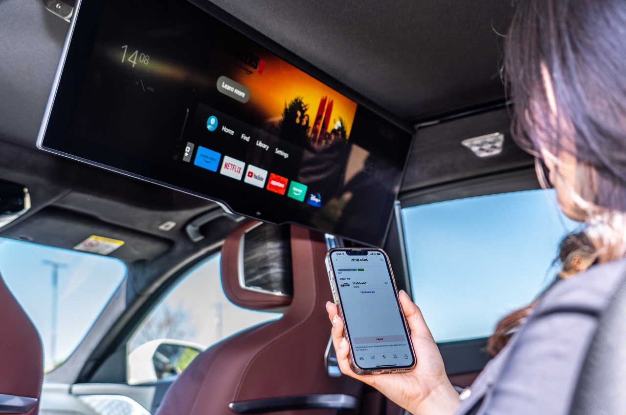 A customer browses through various video content streaming services from the backseat of a BMW vehicle using an in-car eSIM plan. (SK Telecom)