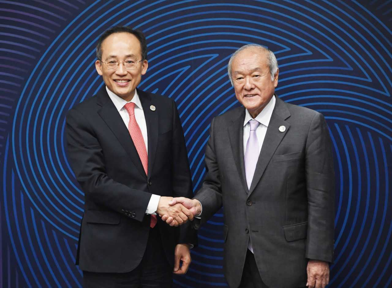 Finance Minister Choo Kyung-ho (left) shakes hands with Japanese Finance Minister Shunichi Suzuki as they meet at the Songdo Convensia convention center in Incheon, west of Seoul, Tuesday. (Ministry of Finance)
