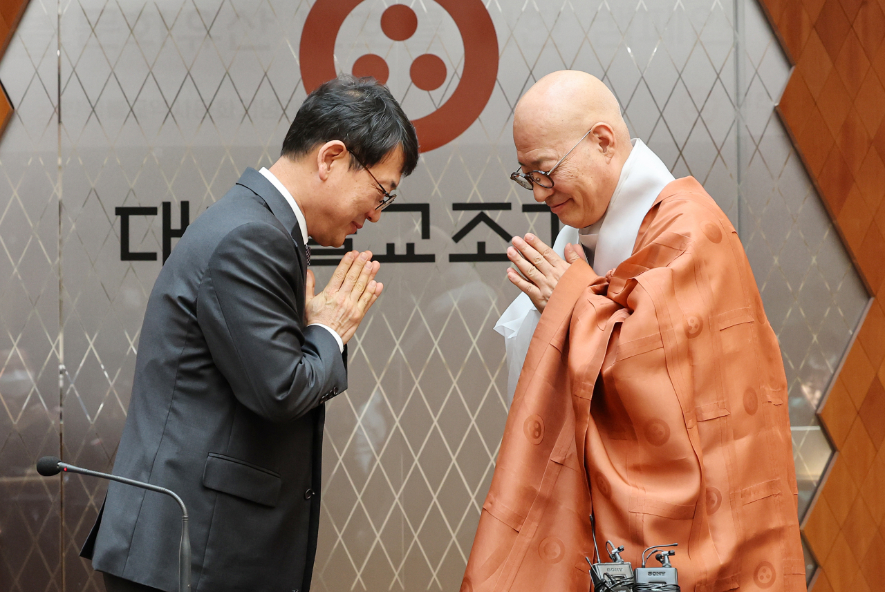 Cultural Heritage Administration Head Choi Eung-chon (left) and Ven. Jinwoo, president of the Jogye Order of Korean Buddhism, greet each other at the Korean Buddhism History and Culture Memorial Hall in Seoul, Monday (Yonhap)