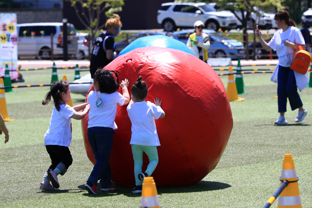 This photo shows children playing with a giant ball at an event in Sokcho, Gangwon Province, on Wednesday. (Yonhap)