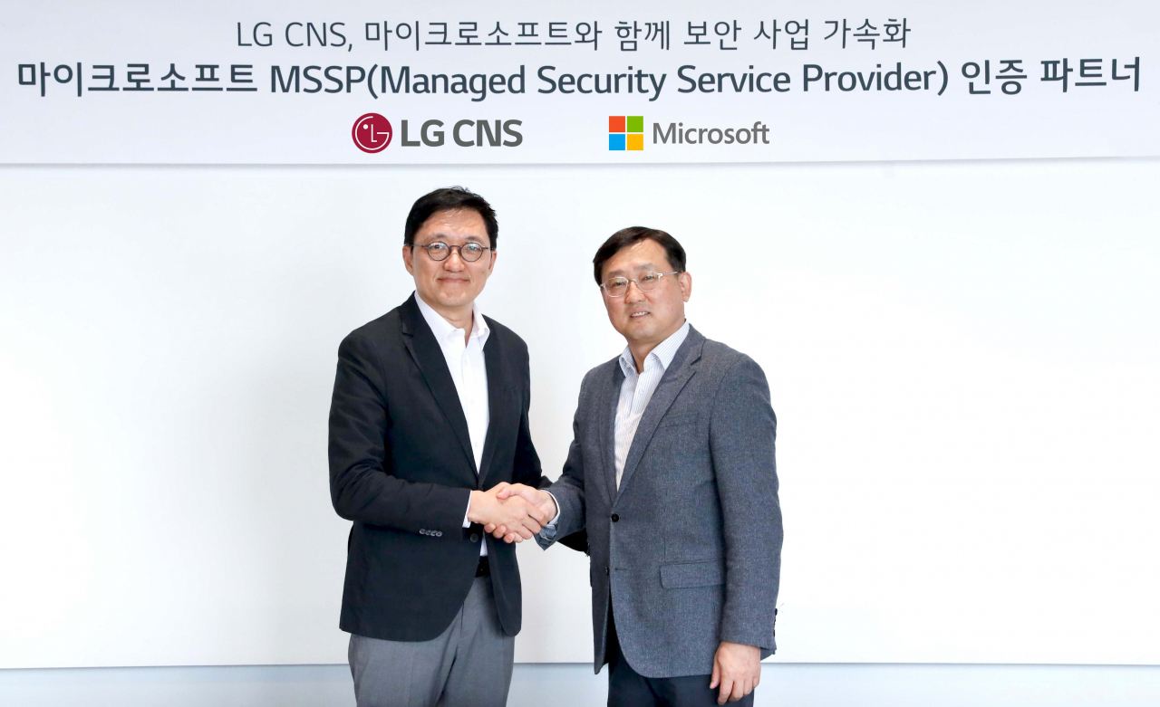 LG CNS security & solution business division head Bae Min (left) and Microsoft Korea global partner solutions lead Chang Hong-kook pose for photos together on Tuesday. (LG CNS)