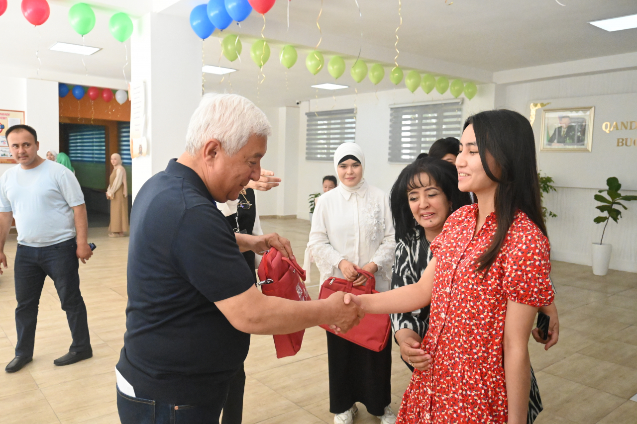 Deputy Mayor of Tashkent Rakhmanov congratulates an 18-year first-time voter at a polling station in Almazar district of Tashkent city on Sunday. (Sanjay Kumar/The Korea Herald)