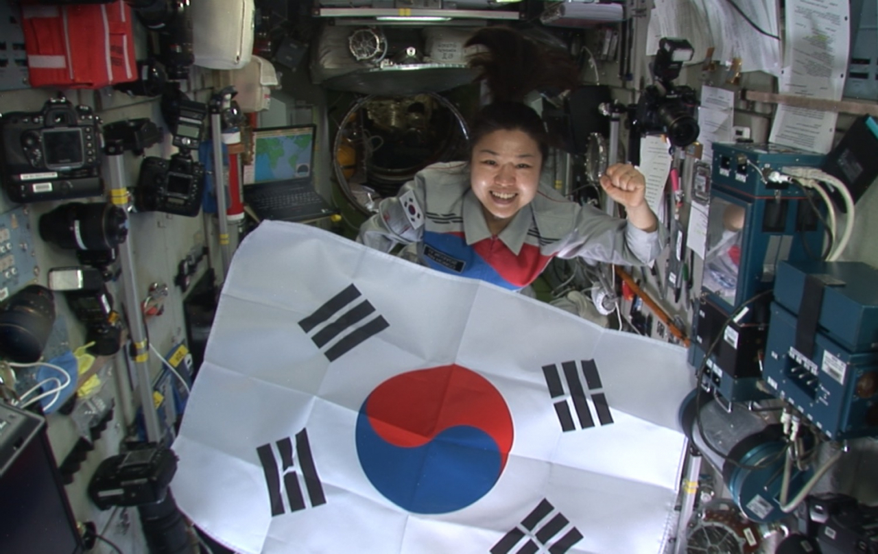 Korean astronaut Yi So-yeon holds up the national flag of South Korea during her mission at the International Space Center in April, 2008. (Wisdomhouse)