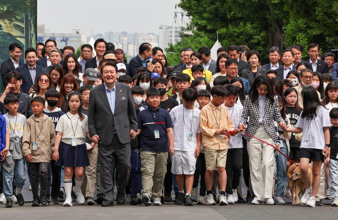 President Yoon Suk Yeol and first lady Kim Keon Hee enter Yongsan Children's Garden with a group of children in front of the presidential office in Seoul on Thursday to open the newly constructed park on the eve of the Children's Day holiday. (Yonhap)