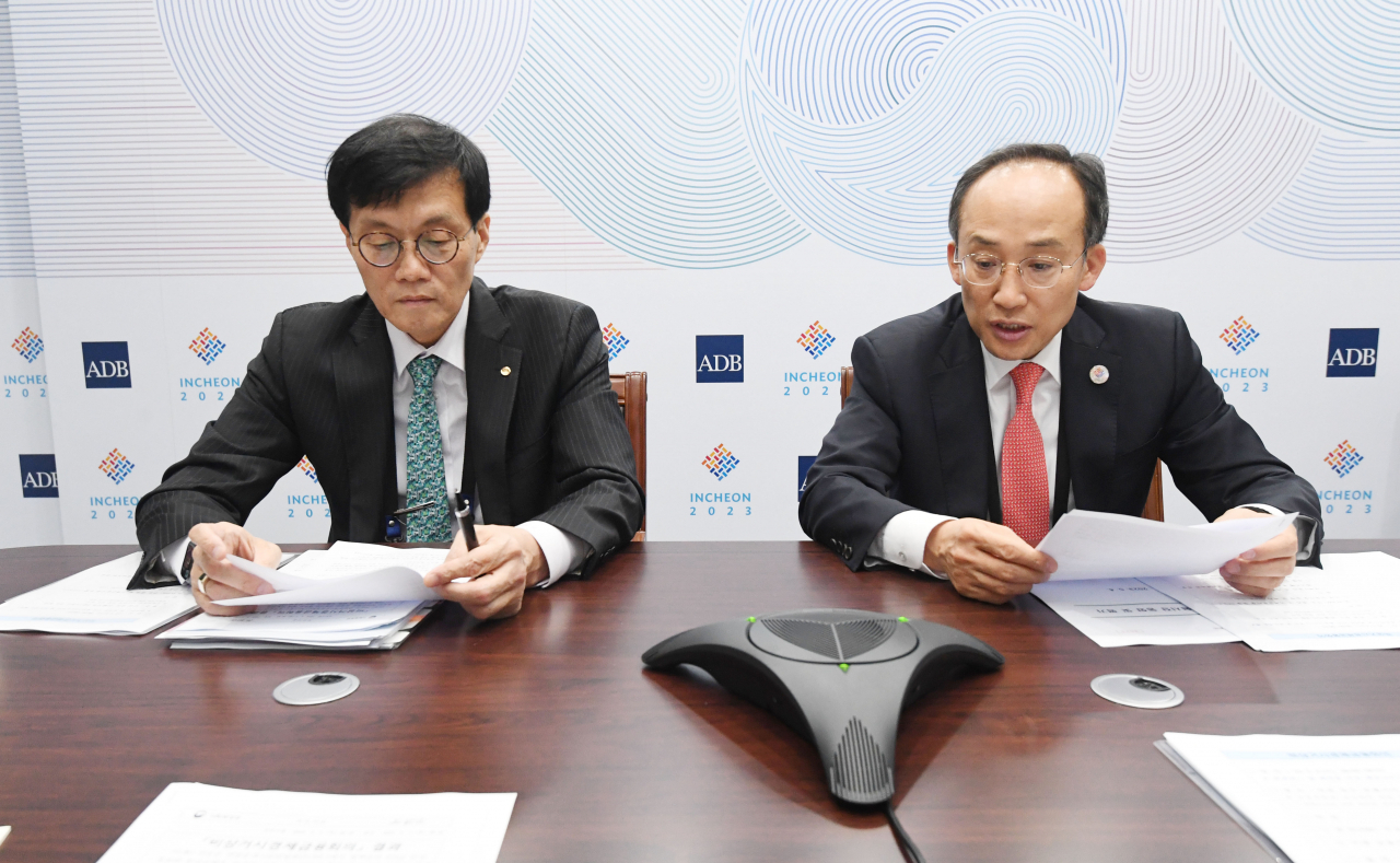BOK Governor Rhee Chang-yong (left) Finance Minister Choo Kyung-ho speak at a meeting held at Songdo Convensia, Incheon, Thursday. (Yonhap)