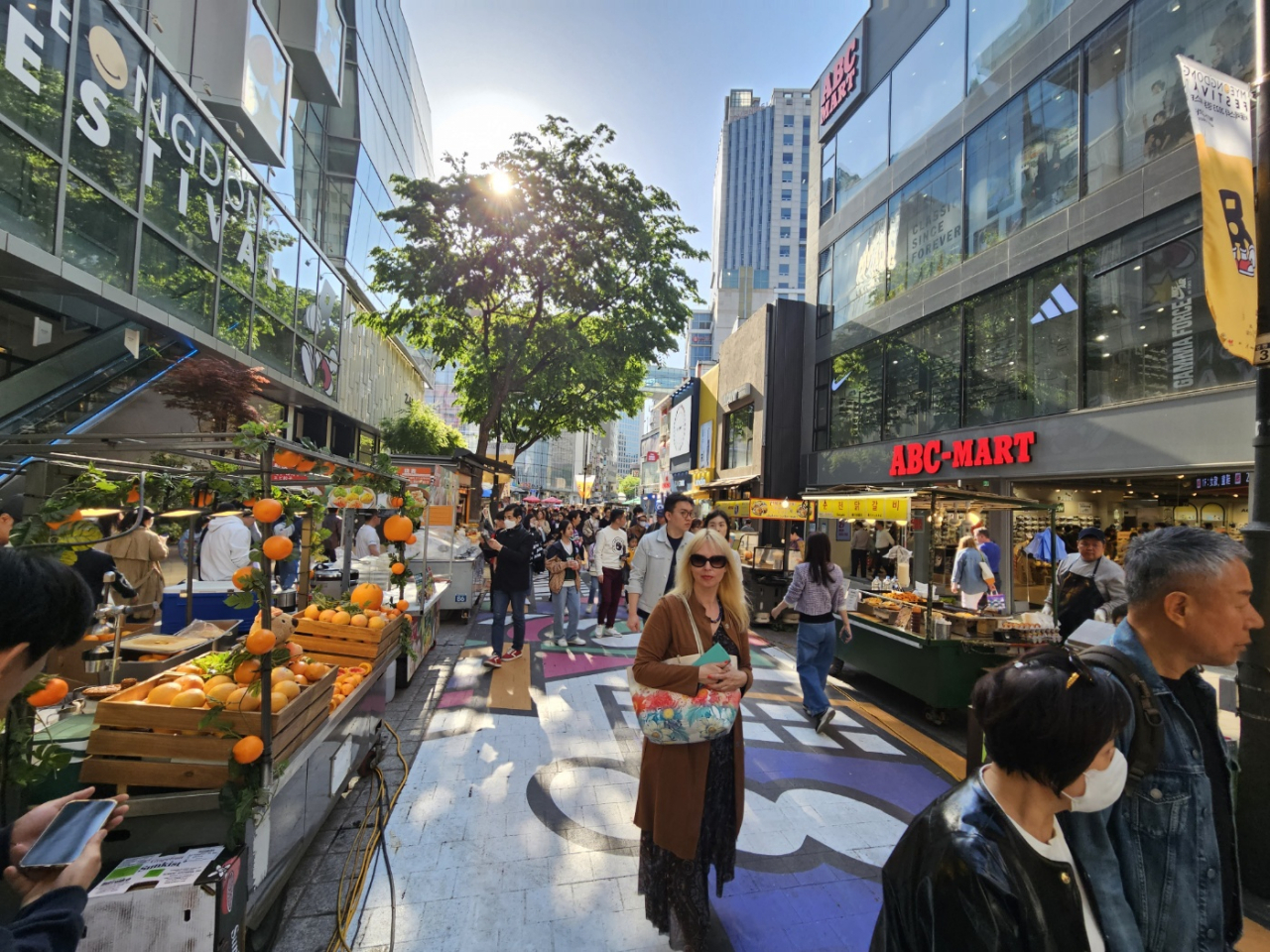 People walk along the main street of Myeongdong where a variety of food vendors are set up. (Park Yuna/The Korea Herald)