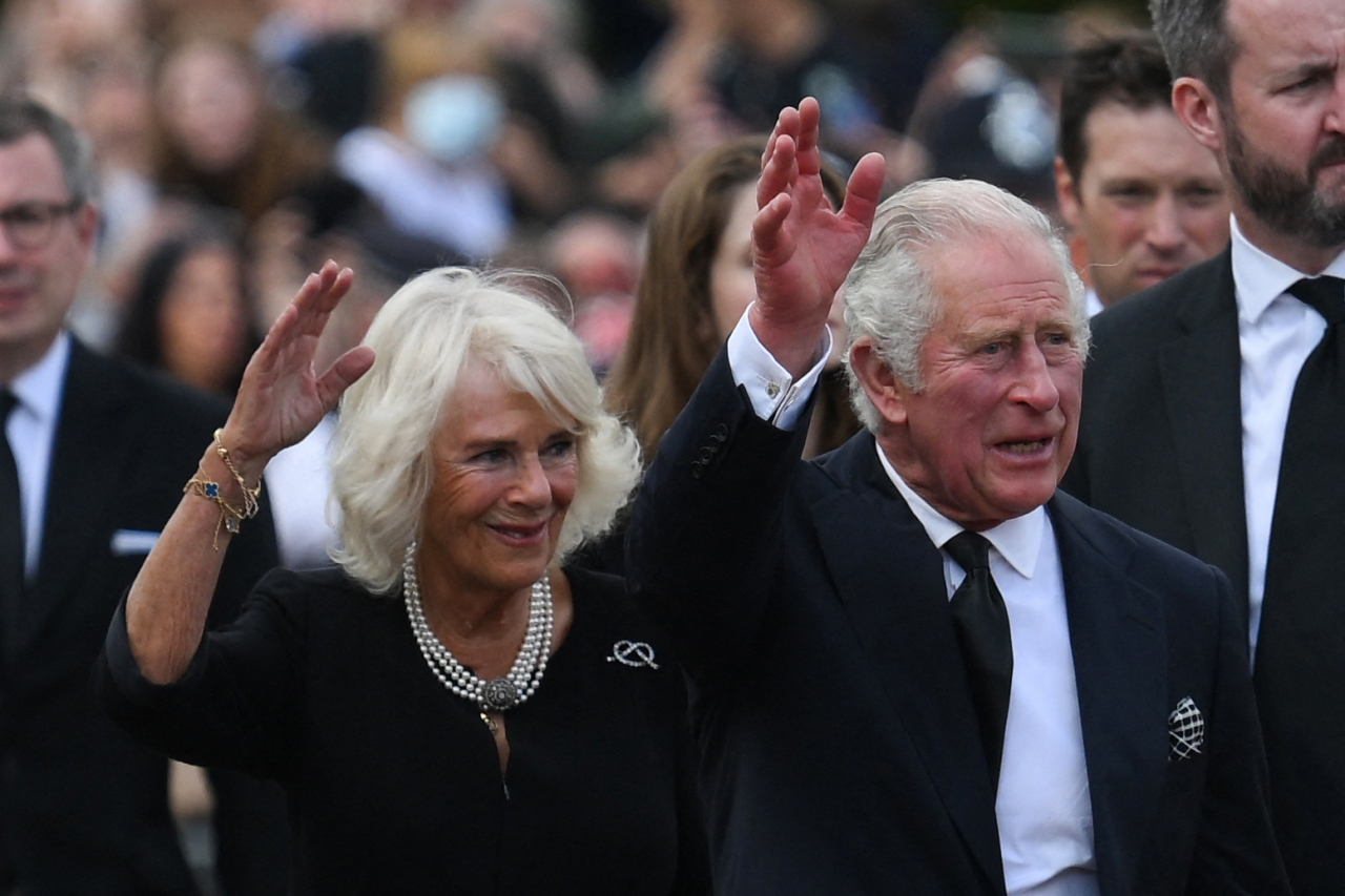 In this file photo taken on September 9, 2022 Britain's King Charles III and Britain's Camilla, Queen Consort wave as they greet the crowd upon their arrival Buckingham Palace in London, a day after Queen Elizabeth II died at the age of 96. Britain's first coronation in 70 years takes place on Saturday, with Charles III crowned king in an elaborate Christian ceremony steeped in solemn ritual and more than a millennium of history. (AFP-Yonhap)