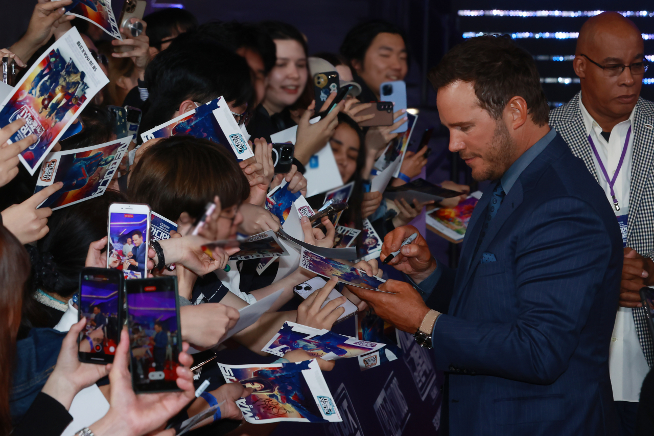 American actor Chris Pratt signs an autograph for a fan at the red carpet event for Marvel Studios' upcoming film, 