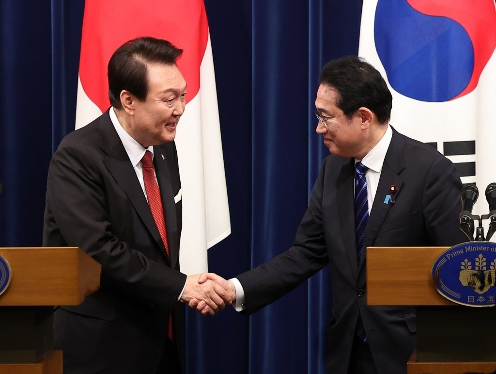 In this file photo, President Yoon Suk Yeol (left) shakes hands with Japanese Prime Minister Fumio Kishida at the end of their joint news conference after their summit in Tokyo on March 16. (Yonhap)