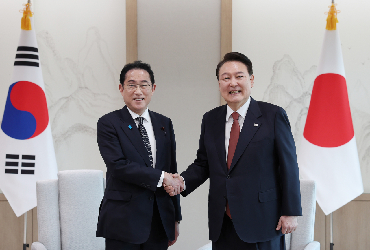 President Yoon Suk Yeol and Japanese Prime Minister Fumio Kishida shake hands at the South Korea-Japan summit meeting held at the presidential office in Yongsan-gu, Seoul, on Sunday. (Yonhap)