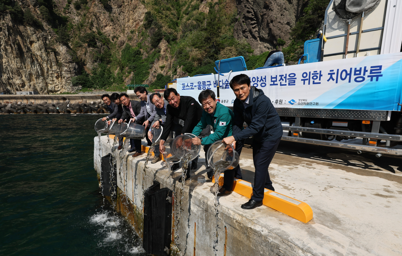Officials of Posco and Ulleung County release young fat greenling fishes into Posco's artificial reef called 