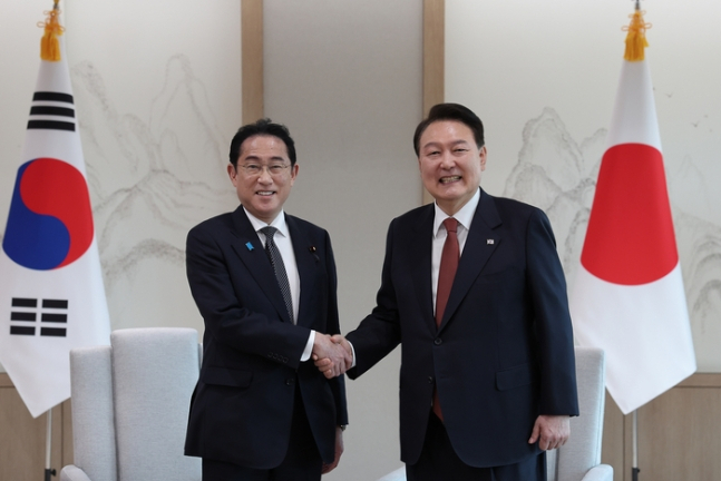 President Yoon Suk Yeol (right) and Japanese Prime Minister Fumio Kishida shake hands at the Korea-Japan summit meeting held at the presidential office in Yongsan, Seoul, Thursday. (Yonhap)
