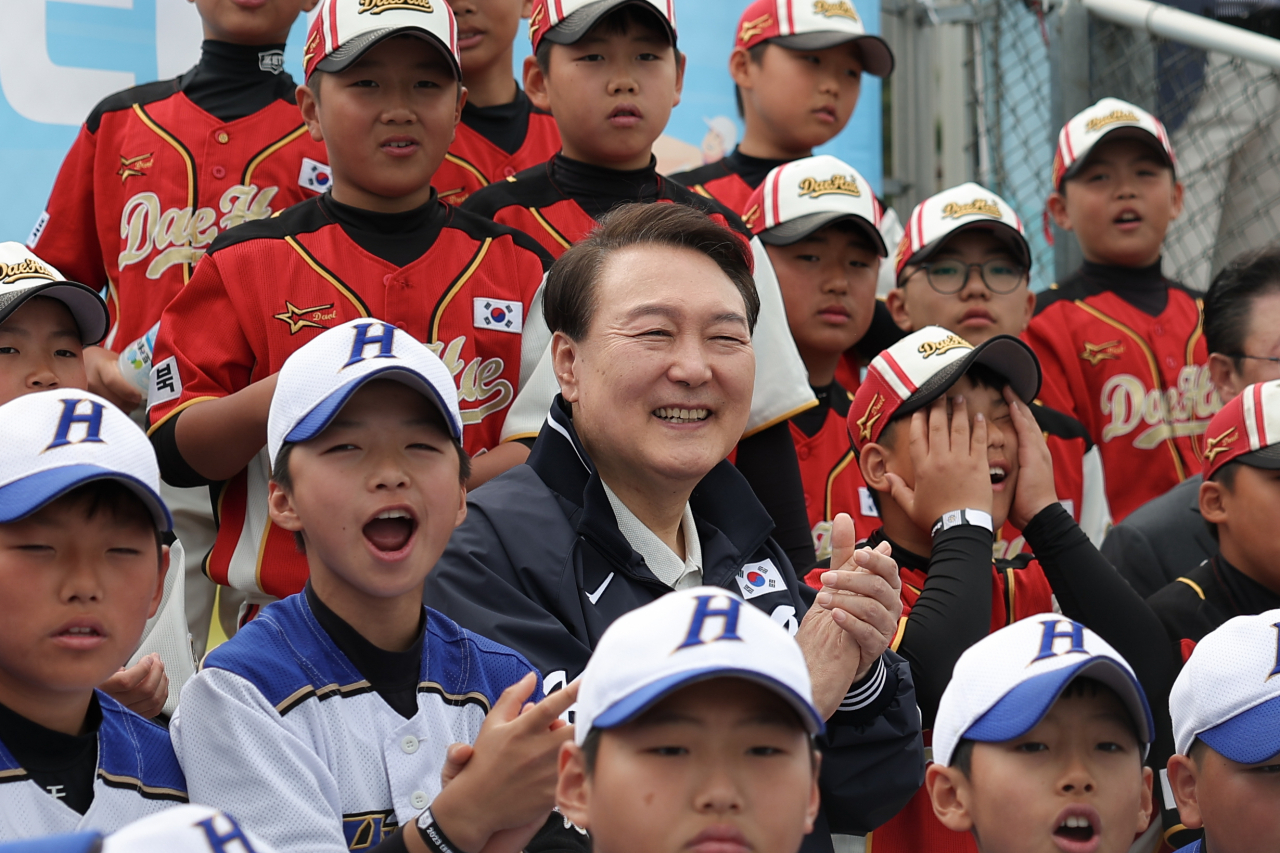 President Yoon Suk Yeol watches a children's baseball game at Yongsan Children's Garden in Seoul on Sunday. (Presidential office)