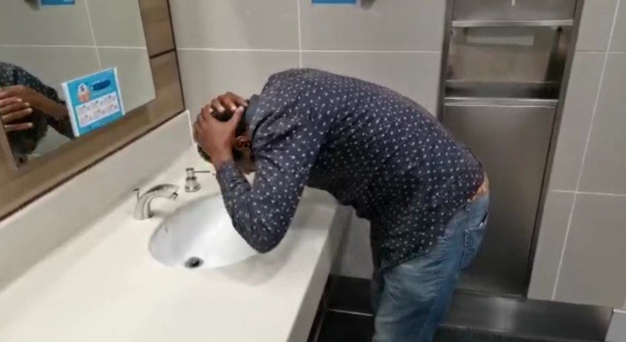 An African asylum seeker washes his hair in a bathroom in Incheon Airport. ( Duroo)