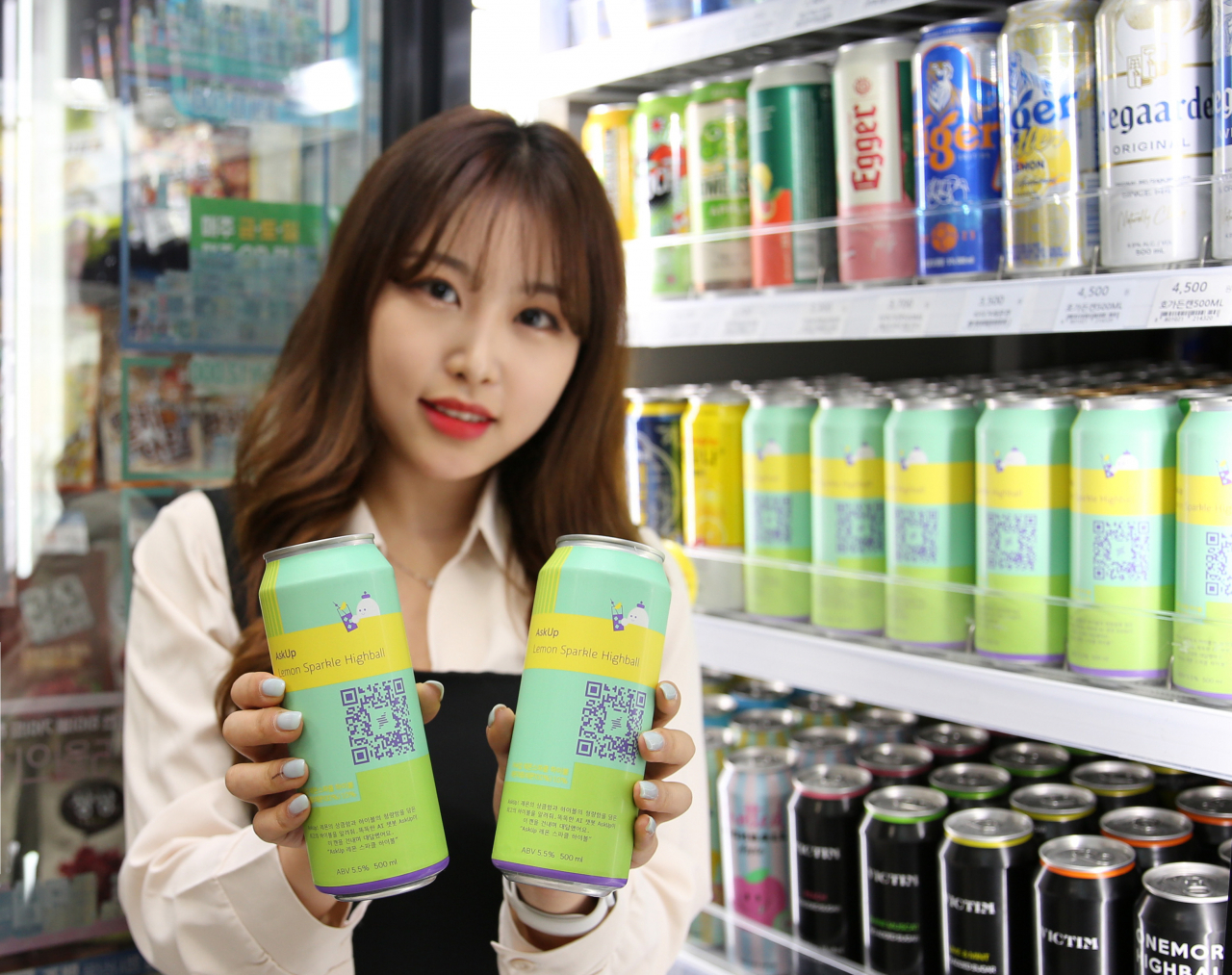 A model holds up cans of AskUp Lemon Sparkling Highball at a GS25 convenience store. (GS25)