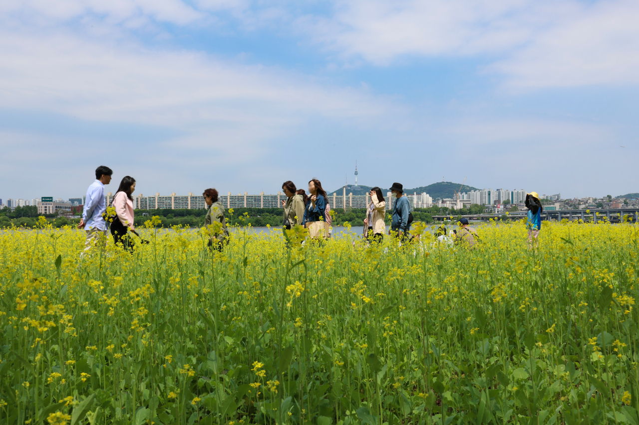 People take a stroll along the Han River in Seoul on Sunday. (Yonhap)