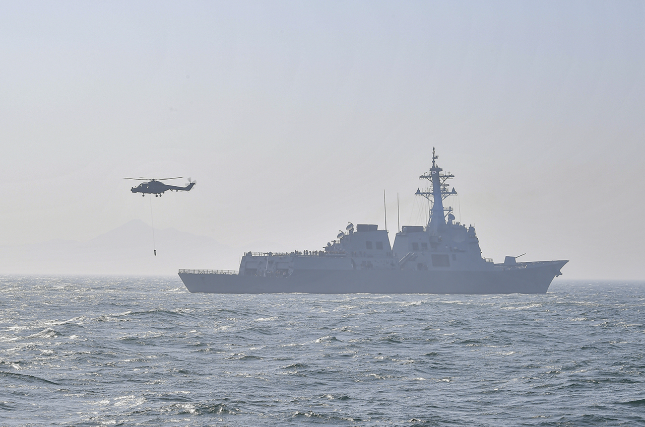 The South Korean Navy’s 7,600-ton Sejong the Great Aegis destroyer and Lynx multi-purpose military helicopter stage an anti-submarine warfare exercise on Tuesday in waters off the island of Gadeokdo in Busan. (Republic of Korea Navy)