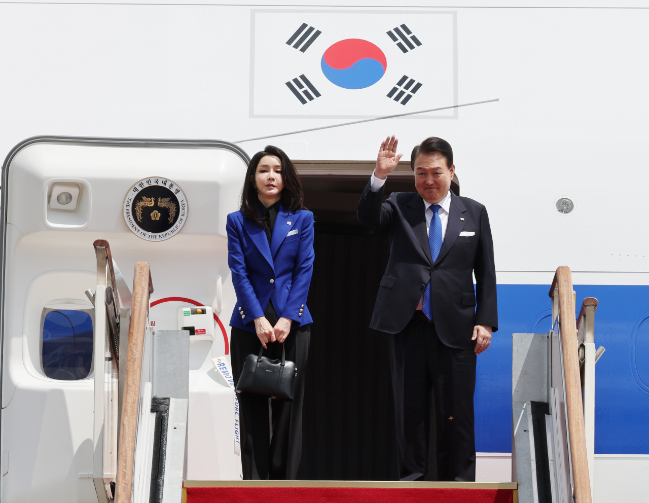 President Yoon Suk Yeol and his wife, Kim Keon Hee, greet officials while boarding the presidential plane at Seoul Airport in Seongnam, Gyeonggi Province, on Friday, prior to departing for Japan to attend the Group of Seven Summit in Hiroshima. (Yonhap)