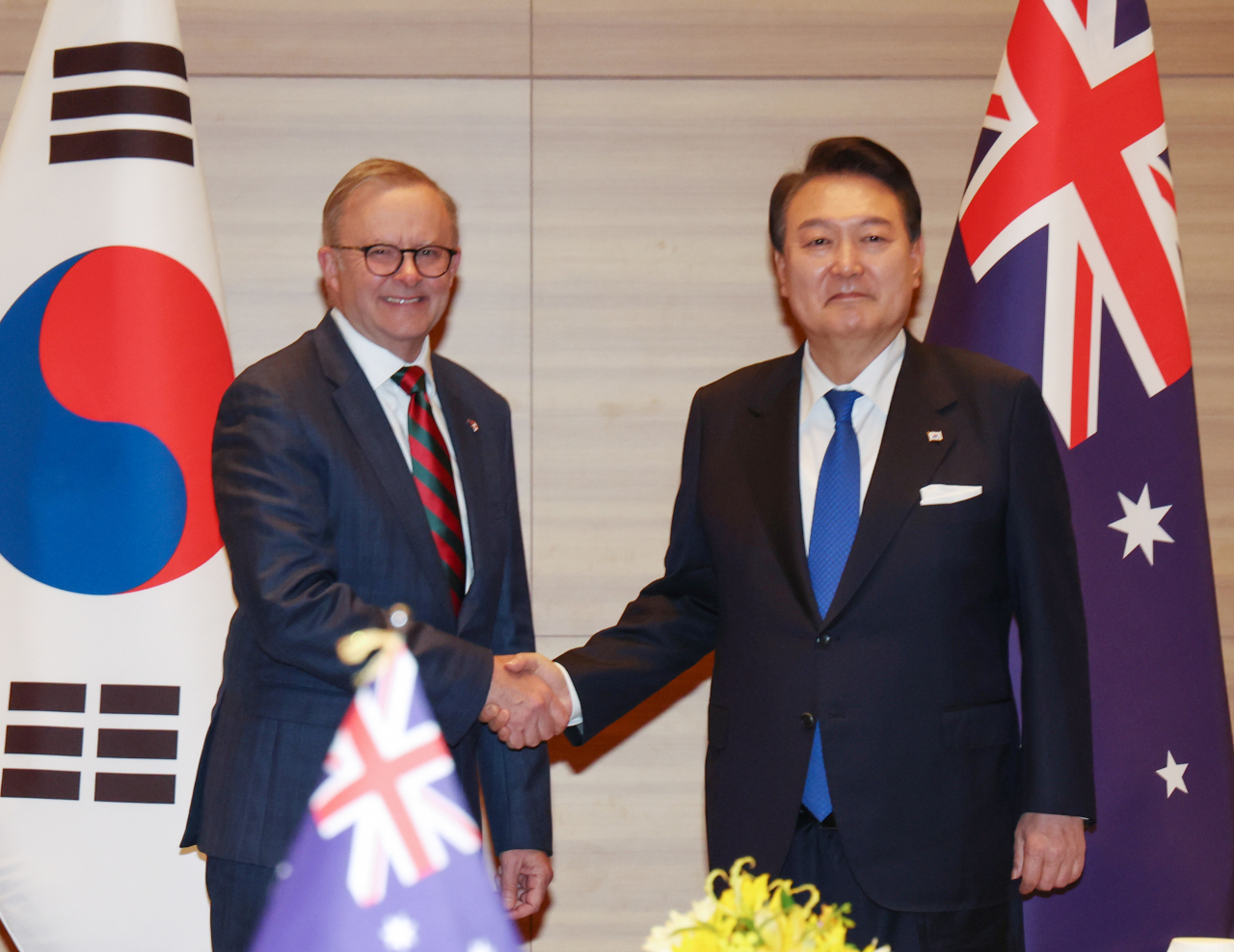 South Korean President Yoon Suk Yeol (R) and Australian Prime Minister Anthony Albanese shake hands during their summit at a hotel in Hiroshima, Japan, on Friday. (Yonhap)