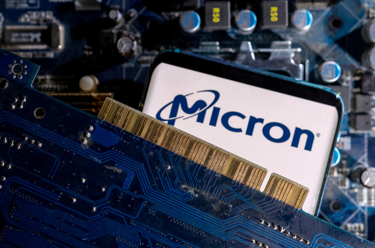 A smartphone with a displayed Micron logo is placed on a computer motherboard in this illustration taken March 6, 2023. (Reuters-Yonhap)