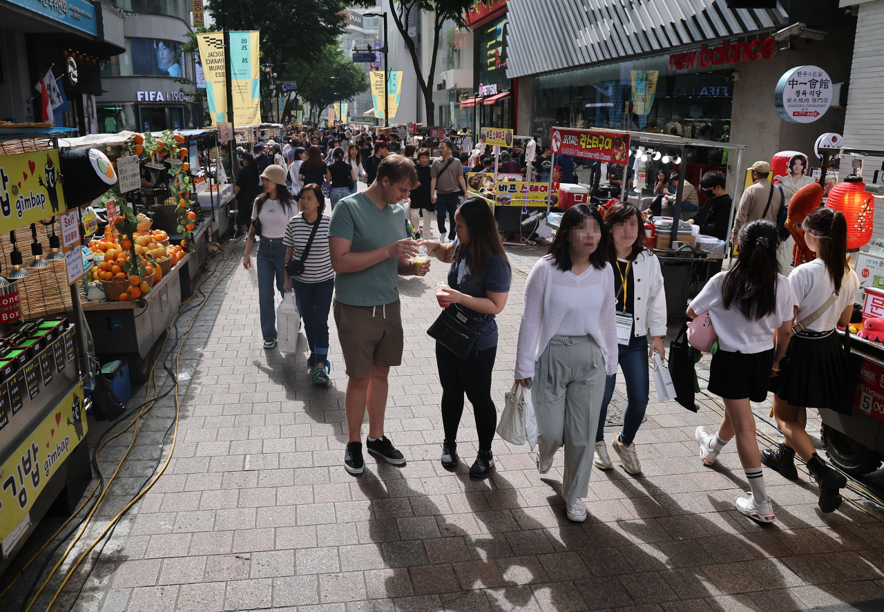 Visitors crowd an alley in Seoul's popular tourist district of Myeongdong in this photo taken Monday, as the streets are vibrant again amid the post-pandemic recovery. (Yonhap)