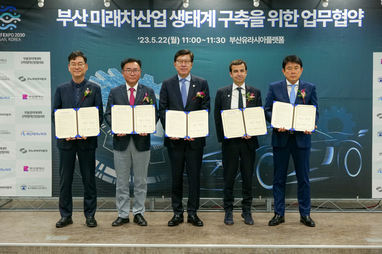 From left: Kim Hyeong-gyun, head of Busan Techno Park, Lee Im-geon, head of Korean University Council Research and Industry Academic Cooperation Administrator, Busan City Mayor Park Hyeong-joon, Renault Korea Motors CEO Stephane Deblaise and Oh Lin-tae, head of Busan Automobile Parts Cooperative, pose after the signing ceremony held at Eurasia Platform in the Busan Station on Monday. (Renault Korea Motors)