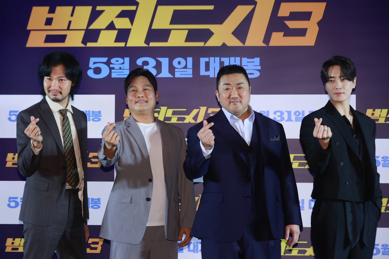 From left: “The Roundup: No Way Out” casts Aoiki Munetaka, director Lee Sang-yong, Ma Dong-seok and Lee Jooh-hyuk pose for a photo at Megabox Coex in Seoul on Monday. (Yonhap)