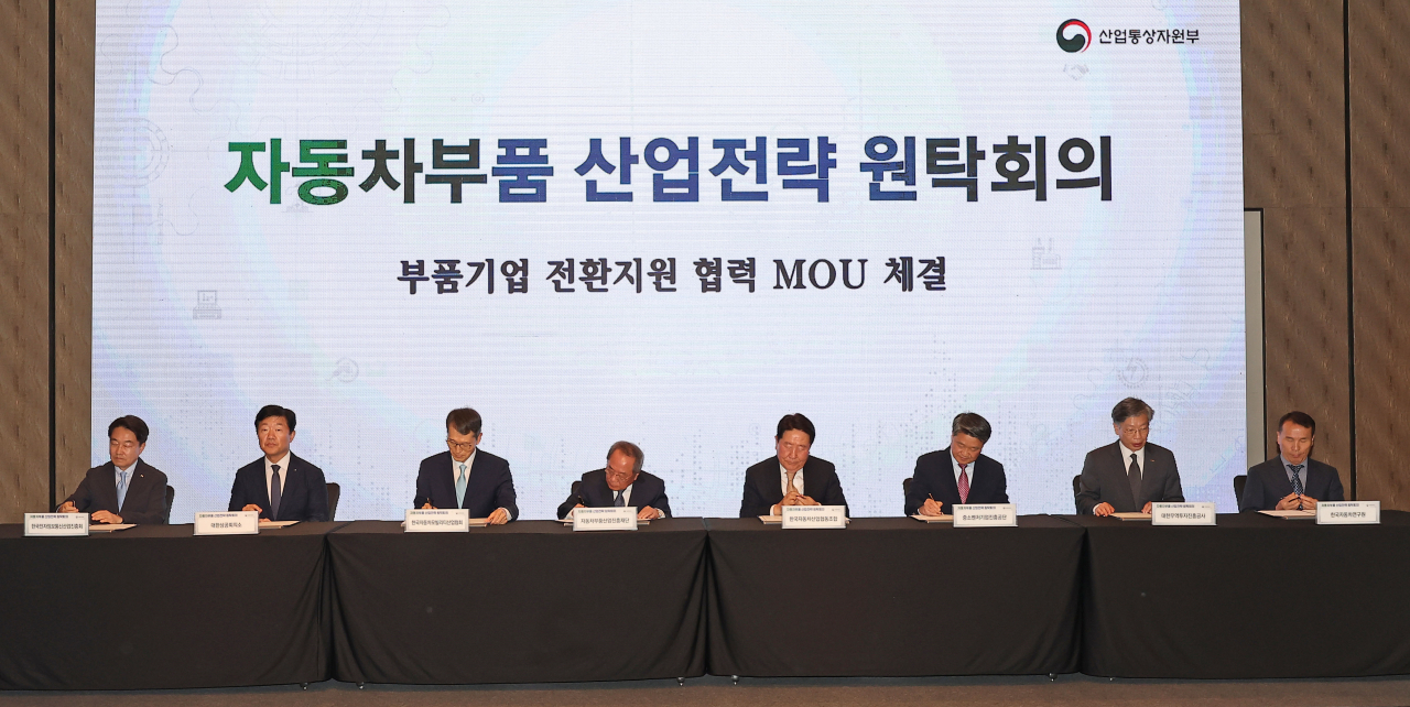 Key officials of the automobile industry sign an agreement during a roundtable meeting in Seoul on Tuesday. (Yonhap)