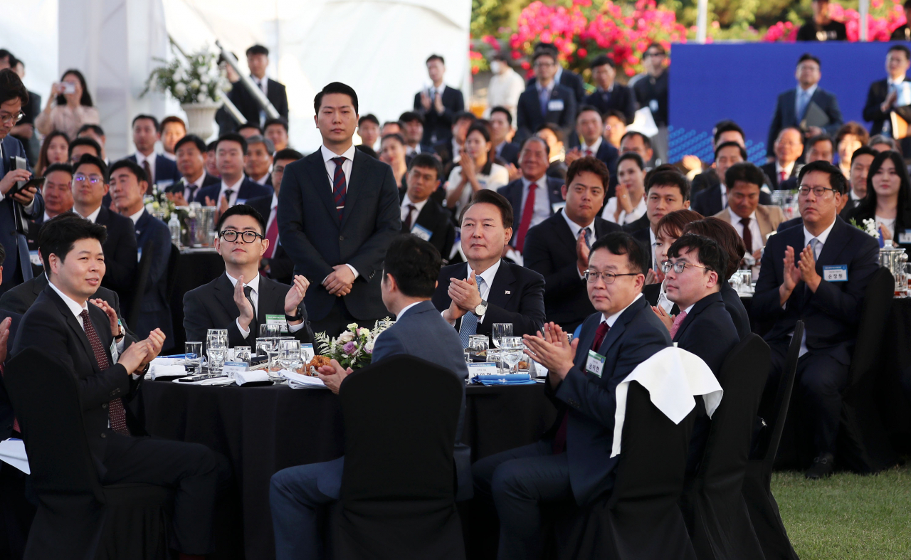 In this photo, President Yoon Suk Yeol is seen with businesspeople on the front lawn of the presidential office in Seoul on Tuesday (Yoon's office)