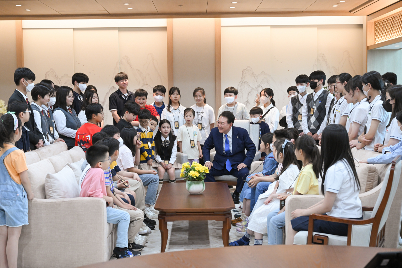 President Yoon Suk Yeol speaks with elementary, middle and high school students at the presidential office building in Yongsan, Seoul, Wednesday. Students were supposed to watch the third launch of the homegrown Nuri rocket, but the launch was postponed due to software error. (Yonhap)