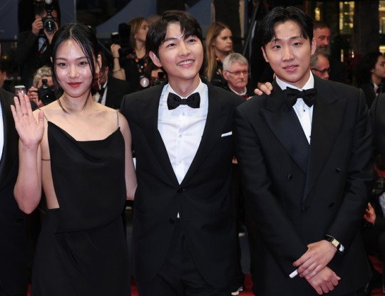 (From left) Actors Kim Hyeong-seo, Song Joong-ki and Hong Sa-bin pose for a photo during a red carpet event at the 76th Cannes Film Festival on Wednesday. (Plus M Entertainment)