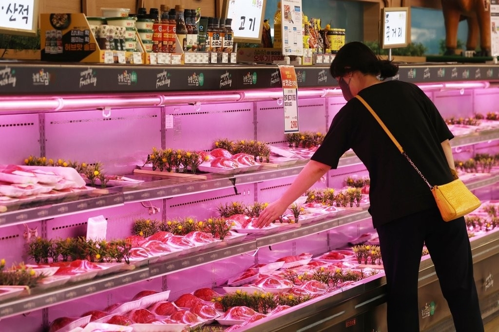 A shopper chooses meat products at a supermarket in Seoul on May 18. (Yonhap)