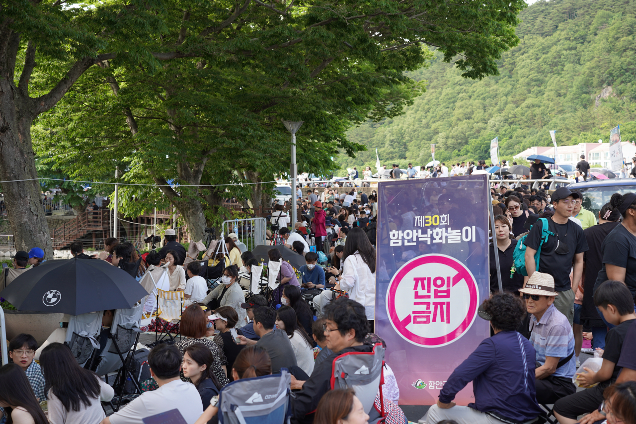 Visitors wait for the Haman Nakhwa Festival to start near Mujinjeong Pavilion in Haman, South Gyeongsang Province, on Saturday. (Lee Si-jin/The Korea Herald)