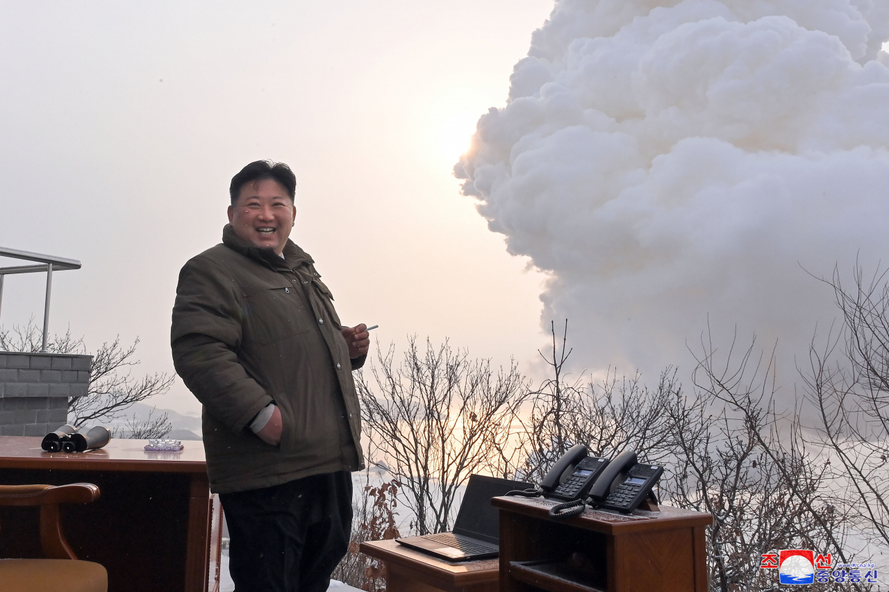 North Korean leader Kim Jong-un smiles contently after watching a ground test of a 