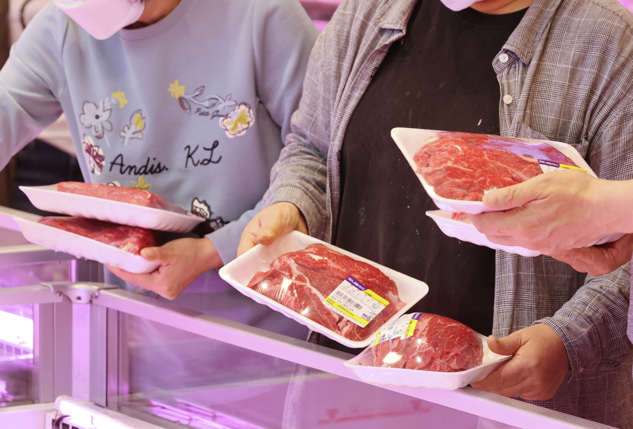 In this file photo, shoppers choose meat products at a supermarket in southern Seoul on May 21. (Yonhap)