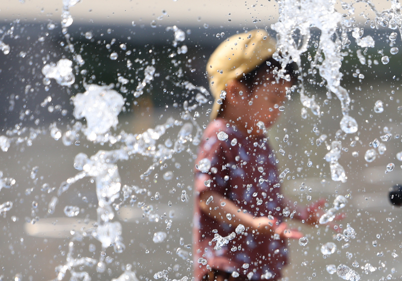 This photo shows a child walking along a fountain in Gwanghwamun Square in central Seoul on May 16. (Yonhap)