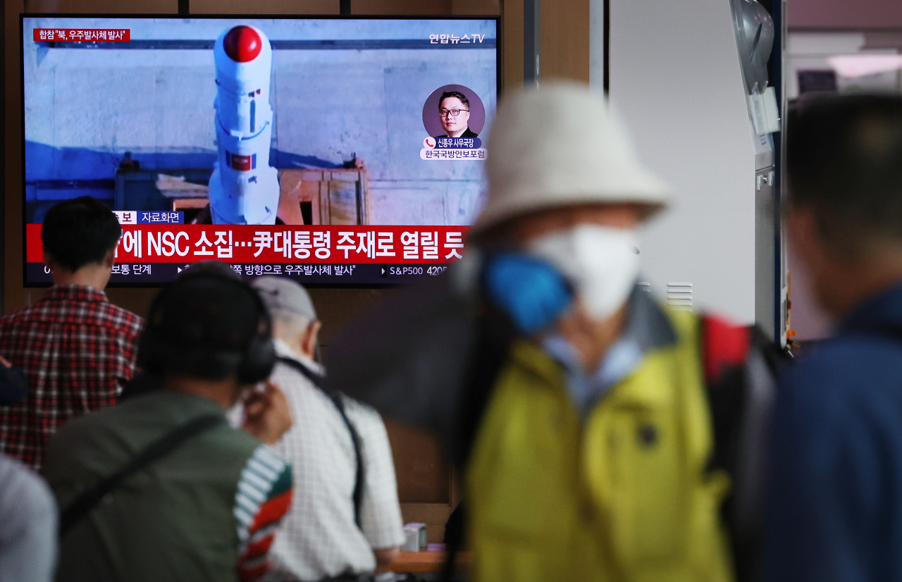 Citizens watch news about North Korea's rocket launch on Wednesday morning in Seoul Station, central Seoul. (Yonhap)