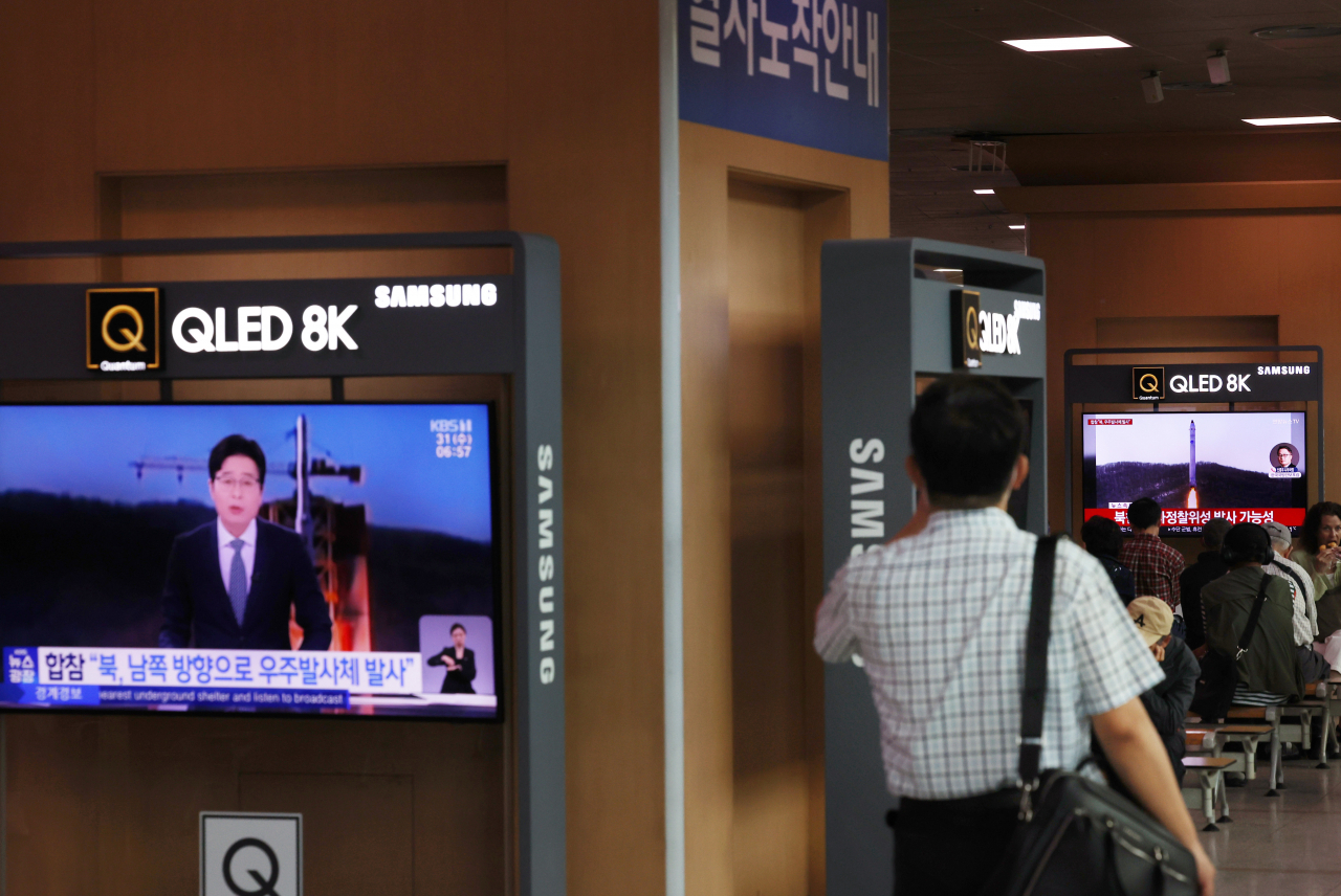 A man passes by a TV news report brief that reads, “North Korea had fired a space satellite” at Seoul Station in central Seoul on Wednesday morning. (Yonhap)