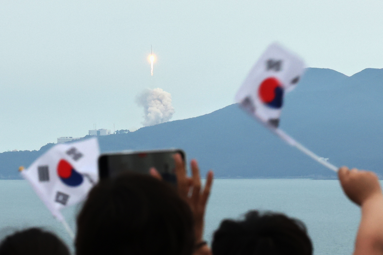 People wave South Korean flags as they watch the third launch of the homegrown Nuri rocket at the Naro Space Center in Goheung, South Jeolla Province, on May 25. (Yonhap)