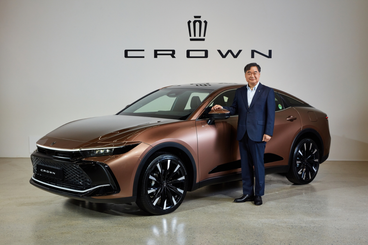 Toyota Korea CEO Konyama Manabu poses with the newly launched Toyota Crown hybrid sedan at a launch event held in Seoul on Monday. (Toyota Korea)