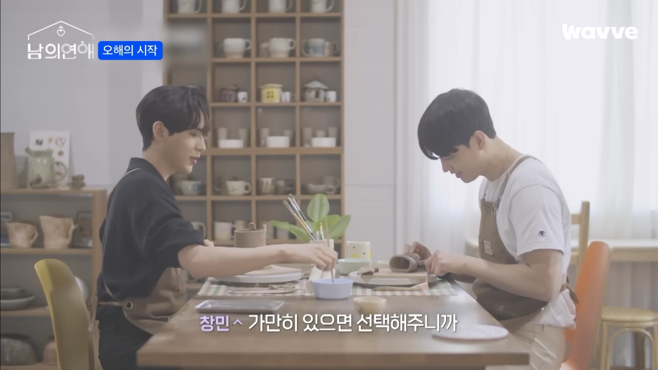 A screenshot shows a gay couple in a pottery studio in 