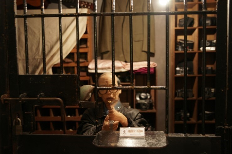 This image depicts a reenacted pawn shop from the past, with iron bars serving as a safety barrier between the owner and clients. (Seoul Metropolitan Archives)