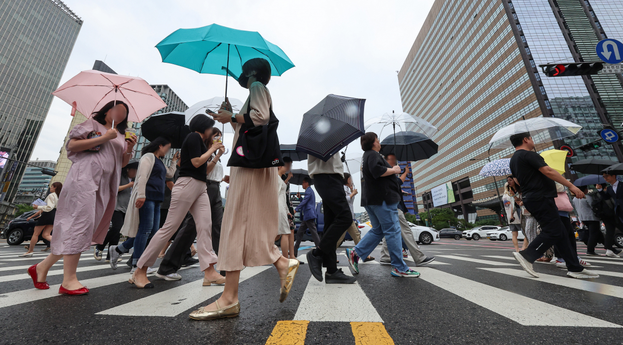 This photo shows people at a crosswalk in Gwanghwamun, central Seoul, Tuesday. (Yonhap)