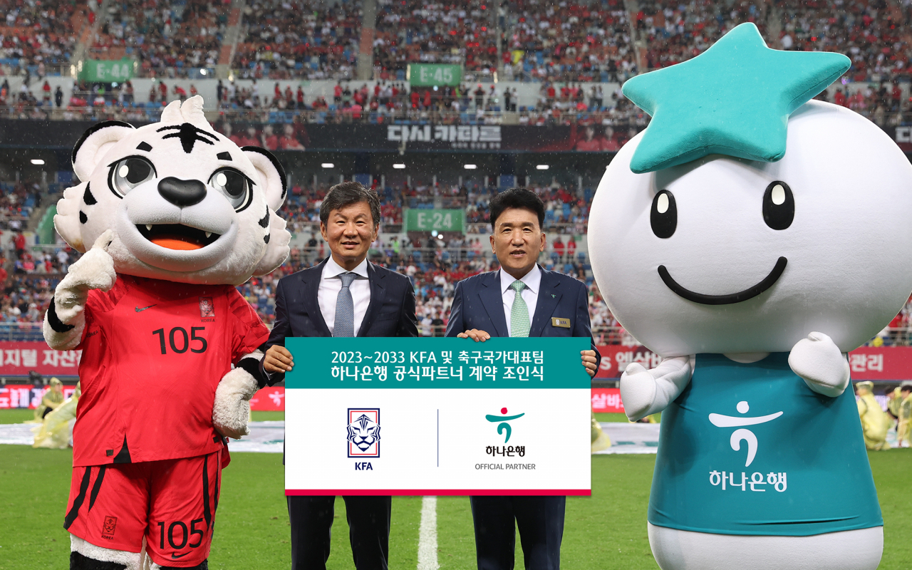 Hana Financial Group Chairman Ham Young-joo (right) and Chung Mong-gyu, head of the Korea Football Association, pose for a photo to celebrate the bank’s 10-year extension of its sponsorship of the KFA during a friendly match between South Korea and El Salvador at Daejeon World Cup Stadium on Tuesday. (Hana Bank)