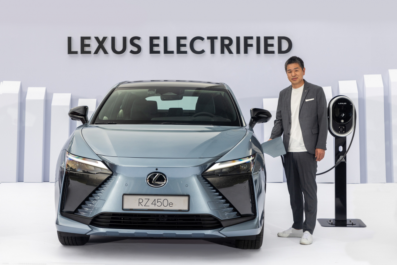 Lexus International CEO Watanabe Takashi poses for a photo next to the Lexus RZ 450e before a press conference at Lotte World Tower in Songpa-gu, Seoul, on Wednesday. (Lexus Korea)