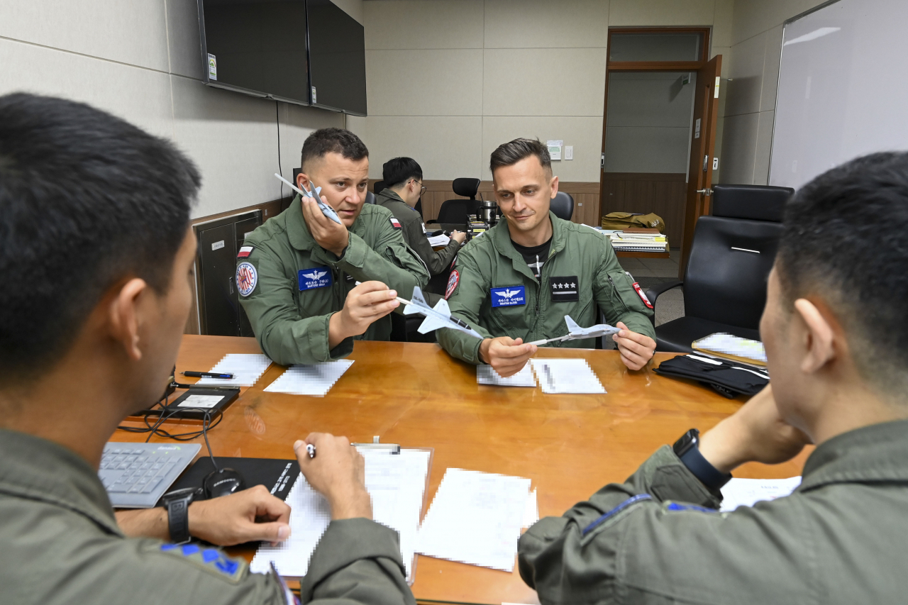 Capt. Sebastian Rajchel of the Polish Air Force (right) and Maj. Bartosz Gula (left) attend a briefing before flying the TA-50 at the South Korean Air Force's 16th Fighter Wing in Yecheon County, North Gyeongsang Province, on Monday. (Republic of Korea Air Force)