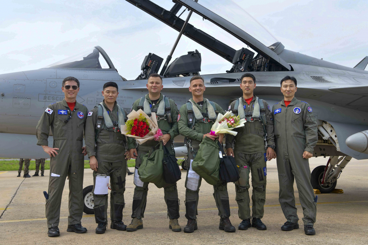 Polish Air Force Maj. Bartosz Gula (third from left) and Capt. Sebastian Rajchel (third from right) take a commemorative photo with South Korean Air Force pilots after completing their final training flight on Monday. (Republic of Korea Air Force)