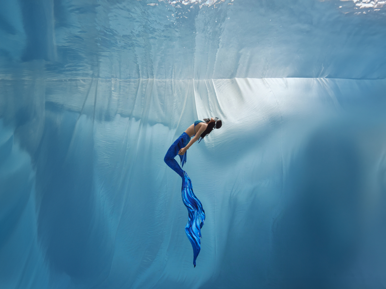 A mermaid practitioner with Mer Freediving swims underwater in this profile photo. (Mer Freediving)