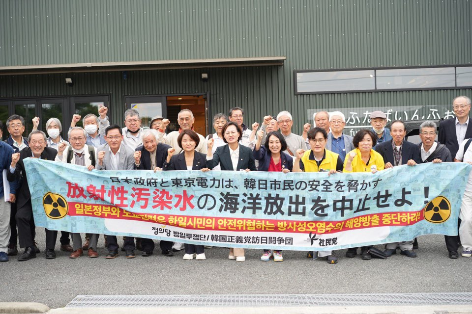 Members of the minor opposition Justice Party pose for a photo with a Japanese civic group on June 23, after touring the Fukushima nuclear plant site during the party's visit to Japan in protest of Tokyo's plan to release wastewater from the crippled plant into the ocean. (Yonhap)
