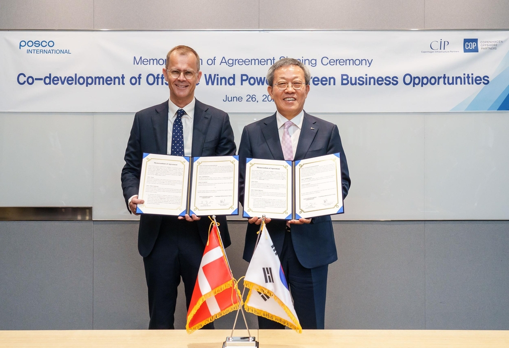 Posco International Vice Chairman and CEO Jeong Tak (right) poses for a photo with Torsten Lodberg Smed (left), senior partner at Copenhagen Infrastructure Partners, after signing a memorandum of agreement on the co-development of offshore wind power and green businesses on Monday. (Posco International)